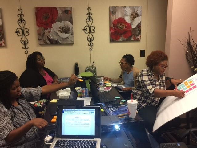 Group of women working on laptops doing lesson plans