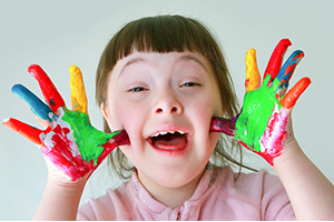 Young girl with painted hands. Special Needs.