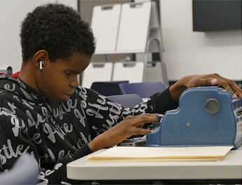 Boy using a brailler