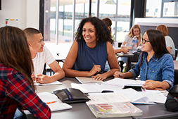 Teacher studying books with students