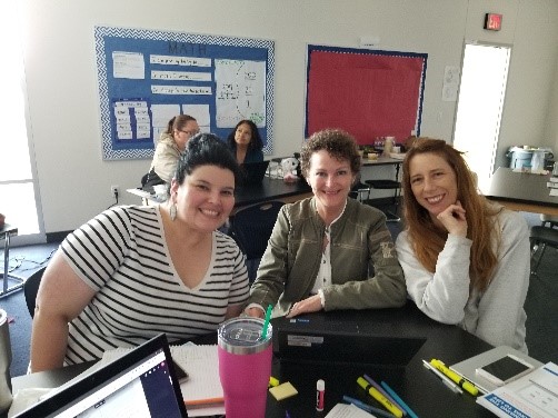 Three LOTE teachers sitting at a table learning to write a performance assessment