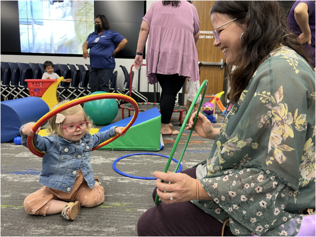 Teacher helping baby use hoops